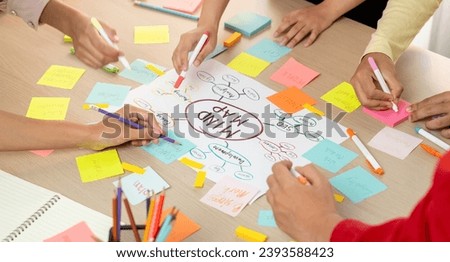 Professional startup group share creative marketing idea by using mind map. Young skilled business people brainstorm business plan while writing sticky notes. Focus on hand. Closeup. Variegated. Royalty-Free Stock Photo #2393588423