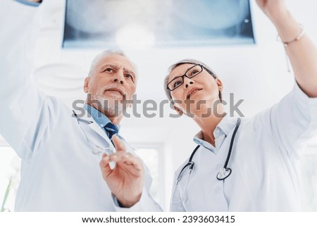 Low angle view medics with x-ray scan at hospital. Bones and rib cage, lungs image in hospital. Respiratory diseases, coronavirus treatment. Pneumonia