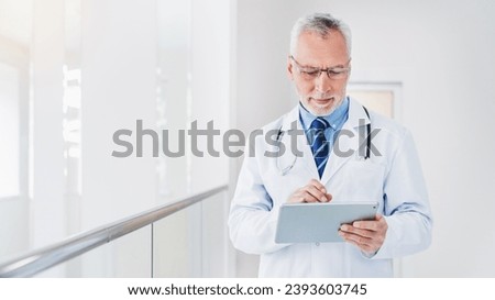 Modern senior doctor using tablet pc in clinic for online medicine, telemedicine. Remote prescription of drugs medicals pills. Family doctor consulting remotely