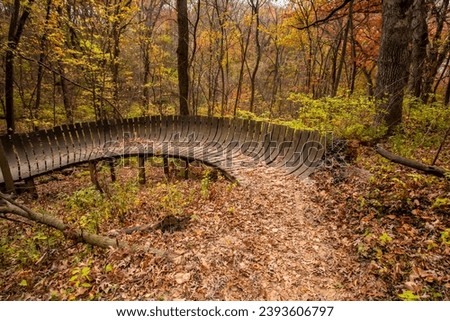 Wooden bike trail in the forest on an autumn day in Iowa.  Royalty-Free Stock Photo #2393606797
