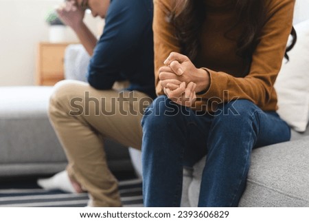 Family problem concept, Close-up hands of Asian wife sitting on sofa and husband sitting back to back in the living room at home have problems in a relationship and have an argument