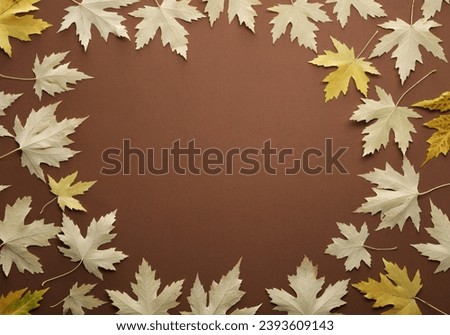 Frame of dry autumn leaves on brown background, flat lay. Space for text