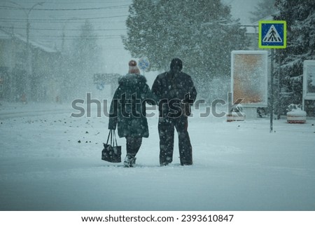 The picture of a pair of grandparents going shopping in a very dangerous time because it is code yellow outside, it has become strong and it is snowing, a cyclone.