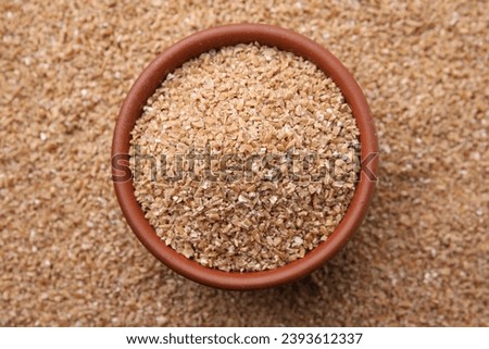 Bowl and dry wheat groats, top view