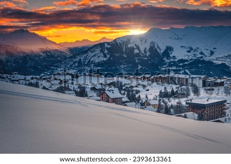 Fabulous winter mountain resort with snowy buildings and fresh snow at sunrise, La Toussuire, France, Europe