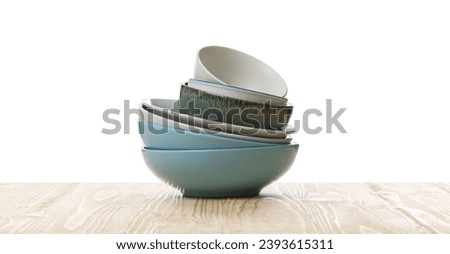 Set of clean color bowls on wooden table against white background