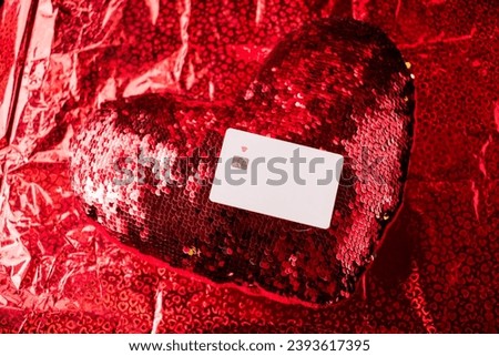 White credit card on red heart in red gift wrap