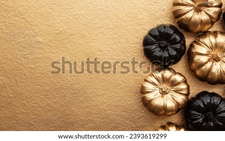 Luxury golden and black decorative pumpkins, top view, golden background Royalty-Free Stock Photo #2393619299