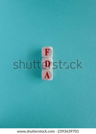 FDA - Food Drug Administration symbol. Wooden cubes with red word FDA. Beautiful blue background. Medical and Food Drug Administration concept. Copy space.