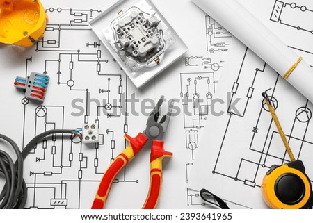 Different electrician's equipment and pliers on wiring diagrams, flat lay Royalty-Free Stock Photo #2393641965