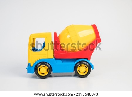 Plastic toy models of construction vehicles. Concrete mixer on a white background.
