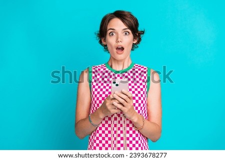Photo of checkered bright dress young girl open mouth astonished read new york times magazine phone isolated on aquamarine color background