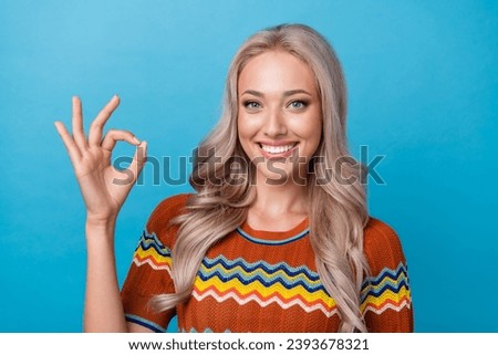 Photo of cheerful sweet girl dressed print shirt smiling showing okey gesture isolated blue color background