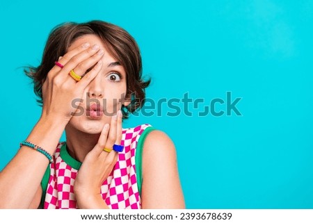 Photo of pretty adorable cute girl wear plaid summer dress hands touch face cover eye blank space isolated on cyan color background