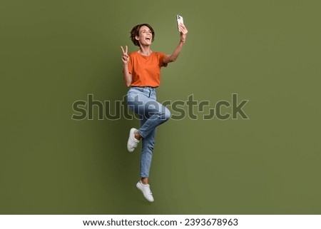 Full size photo of friendly woman dressed t-shirt in glasses show v-sign make selfie on smartphone isolated on khaki color background