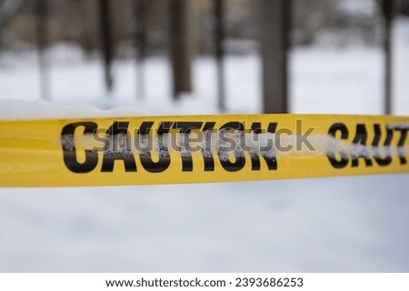 Yellow caution tape. Winter with snow and great cold.