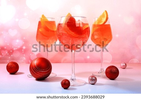 Christmas alcoholic cocktail Aperol spritz in glasses on festive background with fir branches and decorations, bar concept and new year's eve, alcoholic drinks at party, selective focus