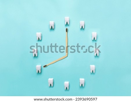 A clock made of plastic models of teeth on a blue background and a toothbrush. Flat lay. Dentistry. Place for text. Oral health and dental examination of teeth. Stomatology. Concept of dental health Royalty-Free Stock Photo #2393690597