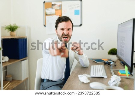 Portrait of an angry hispanic business man and boss pointing and firing an employee because of work problems Royalty-Free Stock Photo #2393722585