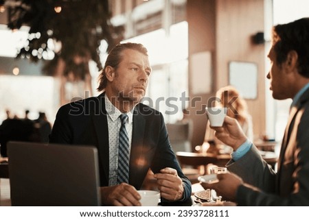Two businessman sitting in cafe talking