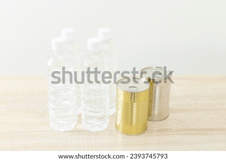 Bottled drinking water and canned food on the desk.