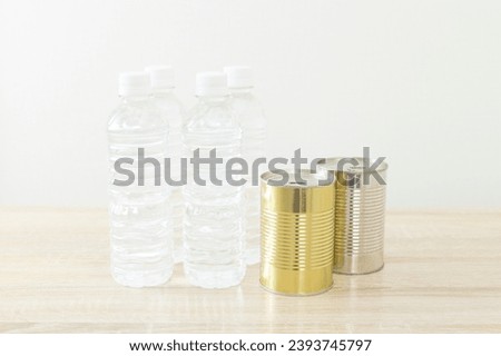 Bottled drinking water and canned food on the desk.