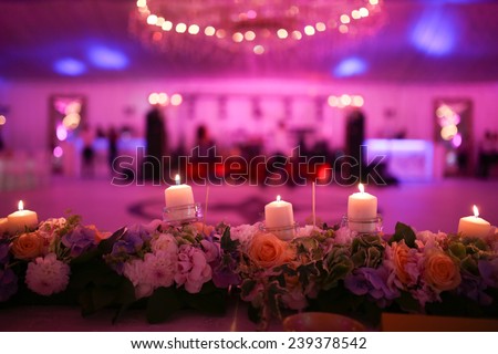 Flaming candles and flowers decoration  Royalty-Free Stock Photo #239378542