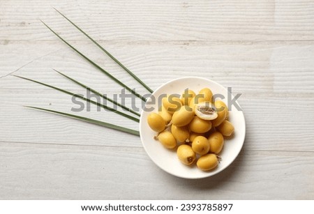 Group of yellow fruit of palm phoenix dactylifera or date palm fruit in
ceramic circle plate isolated on the white wooden table backdrop.healthy food, Traditional, delicious and healthy ramadan
