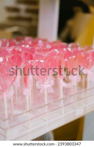 Pink, wrapped in plastic, heart shape lollipops on the rack. Valentine Day or Mother Day little present. 