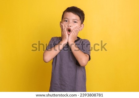 Asian boy in casual style showing shocked surprise expression