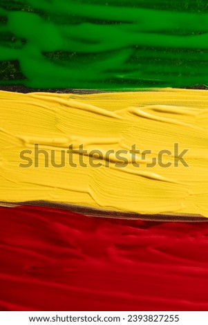 Vertical image of green, yellow and red paints with copy space background. Black history month, africa, black culture and history concept.