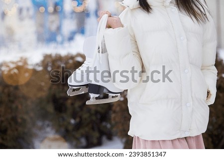 Woman holds ice skates. Winter time, holidays lifestyle, happy holidays.
