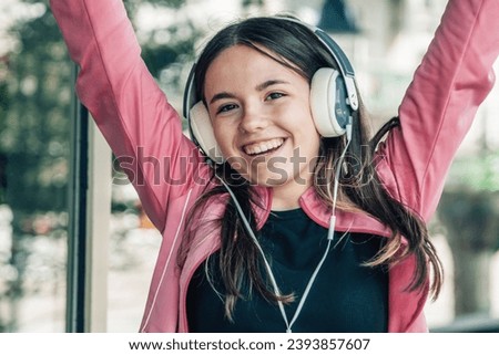 euphoric girl teenager with headphones on the street