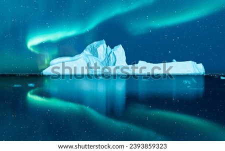 Iceberg floating in greenland fjord  
with aurora borealis - Greenland Royalty-Free Stock Photo #2393859323
