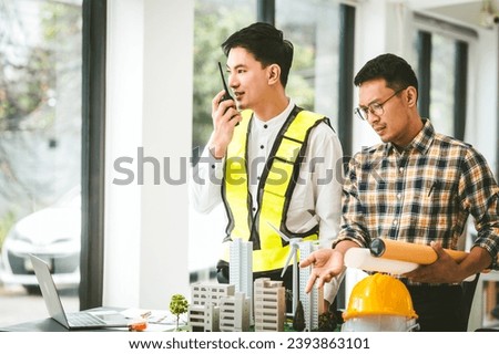Two men engineer housing team meeting, one in safety vest holding color swatches, discussing plans, engineers architects talking house design color. Choosing paint for exterior and interior walls