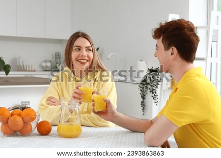 Young couple drinking orange juice in kitchen