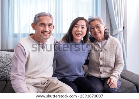 Asian family portrait consist of senior father mother and daughter sitting together with happy smile on cozy couch in retirement home during winter for elder care to spending valuable time