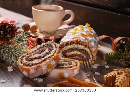christmas poppy seed cake with icing glaze,orange peel and snowflake sprinkles on wooden table
