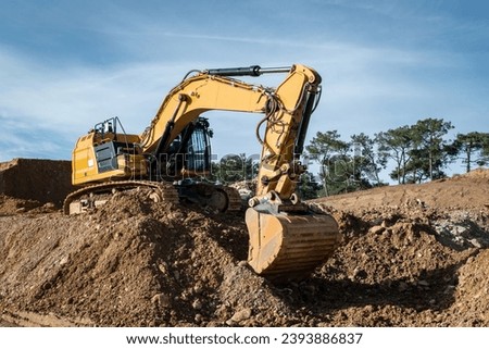 Rotary backhoe excavating earth for the construction of a road Royalty-Free Stock Photo #2393886837
