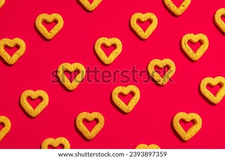 Small heart-shaped cookies on a red background. A beautiful background for Valentine's Day.