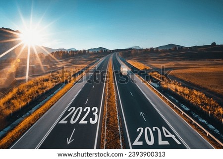 Driving on open road at beautiful sunny day to new year 2024. Aerial view Royalty-Free Stock Photo #2393900313