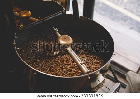 freshly roasted coffee beans n a coffee roaster Royalty-Free Stock Photo #239391856