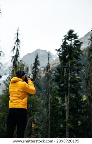 photographer takes pictures of landscapes in a mountain forest