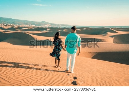 couple walking at the beach of Maspalomas Gran Canaria Spain, men and woman at the sand dunes desert of Maspalomas Spain Europe during vacation