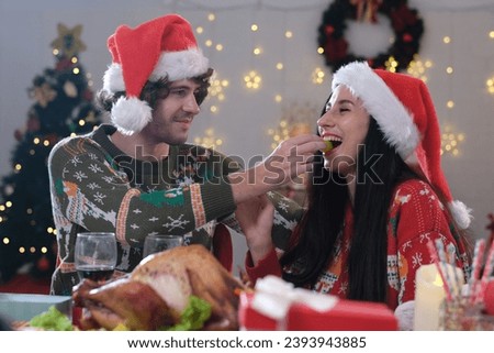 People and holidays concept - Happy couple celebrate christmas party cheering wine over christmas tree on background at home. Lovely family with christmas balls on pine tree on bokeh background.