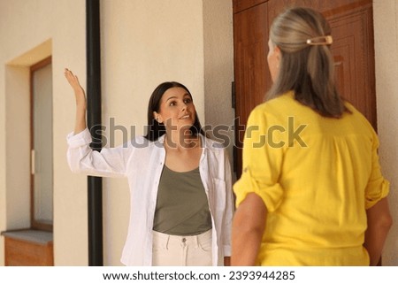 Emotional neighbours having argument near house outdoors Royalty-Free Stock Photo #2393944285
