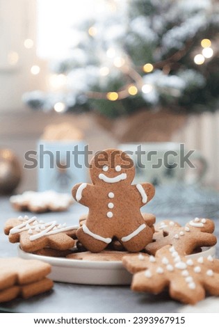 Christmas cookies cut in gingerbread man shape with various cookies in a plate decorated with  royal icing. decoration of Christmas festive ambiance and light bokeh in background