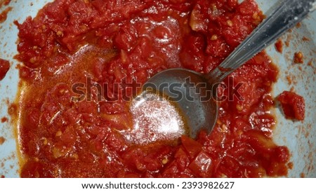 Tomato sauce in a pan with a spoon close-up. Preparation of Italian tomato sauce.