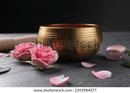 Tibetan singing bowl and beautiful rose flowers on gray table Royalty-Free Stock Photo #2393984077