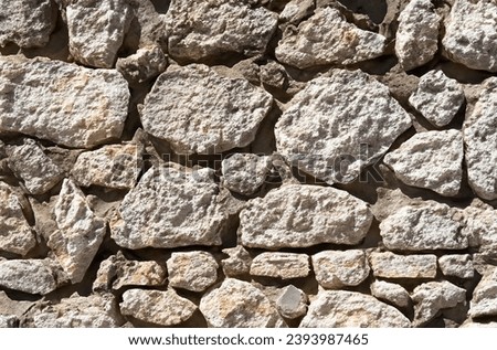 Gray old Rugged stone wall with natural texture pattern. Natural rock arrangement surface wall background. 